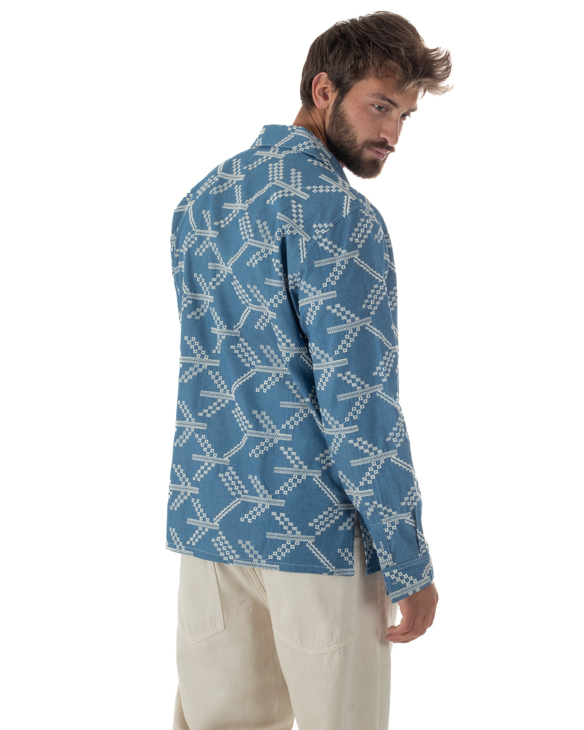 Dettaglio ricami allover geometrici etnici su fondo blu denim camicia uomo