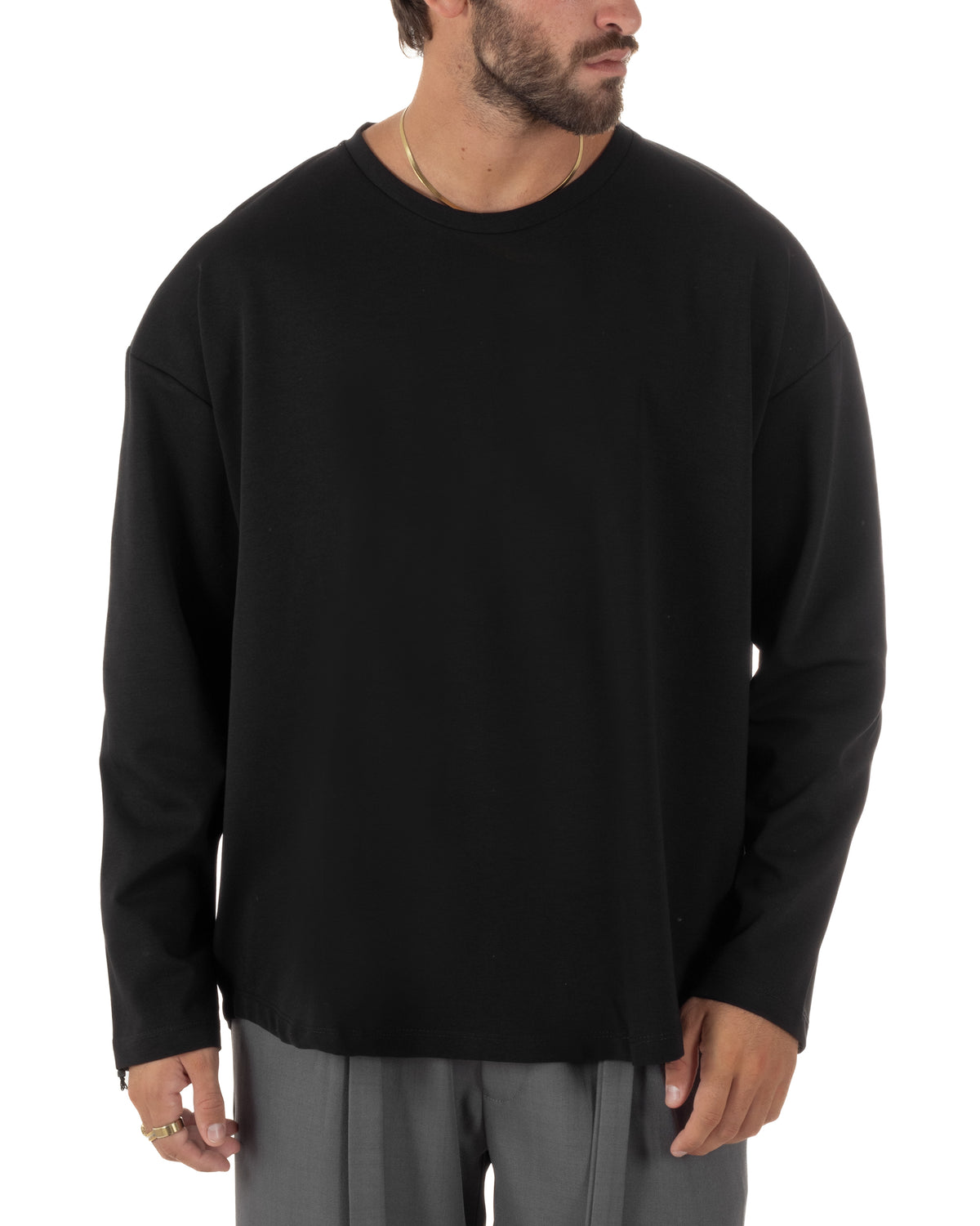 Maglia nera uomo oversize a maniche lunghe con spalle scese, girocollo pulito e fondo dritto dal design minimal.
