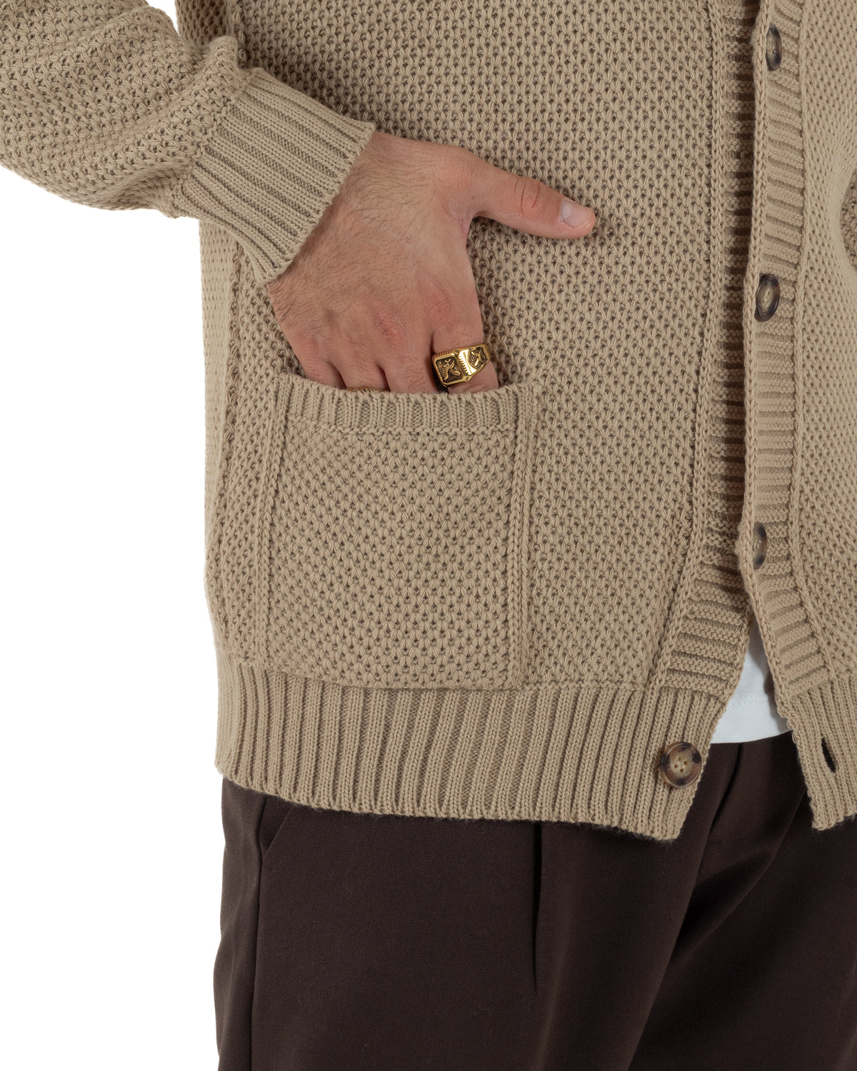 Tasche con bordo a coste e maniche lunghe del cardigan polo beige, indossato aperto di tre quarti.