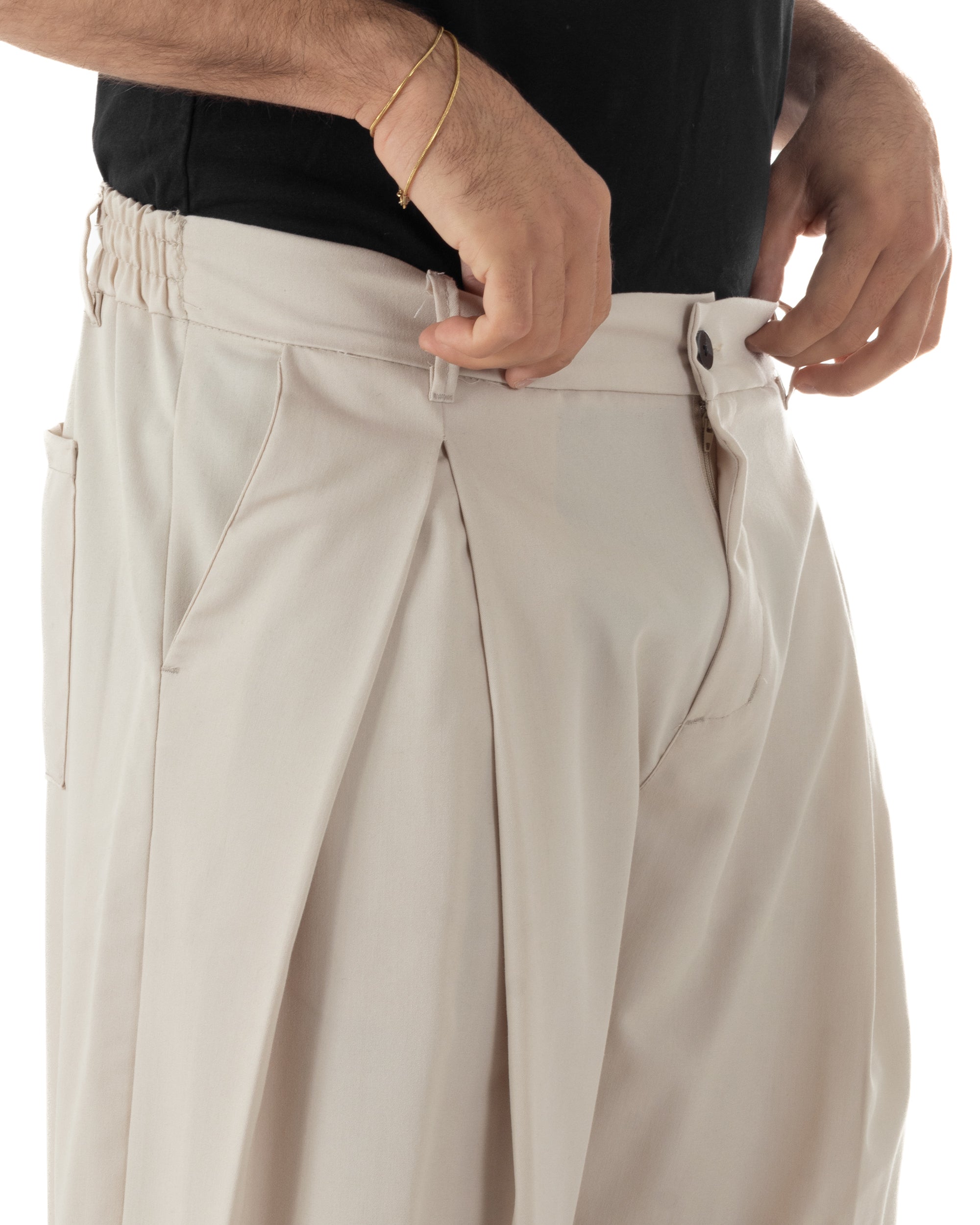 Dettaglio pinces ampie anteriori pantaloni beige baggy wide fit uomo