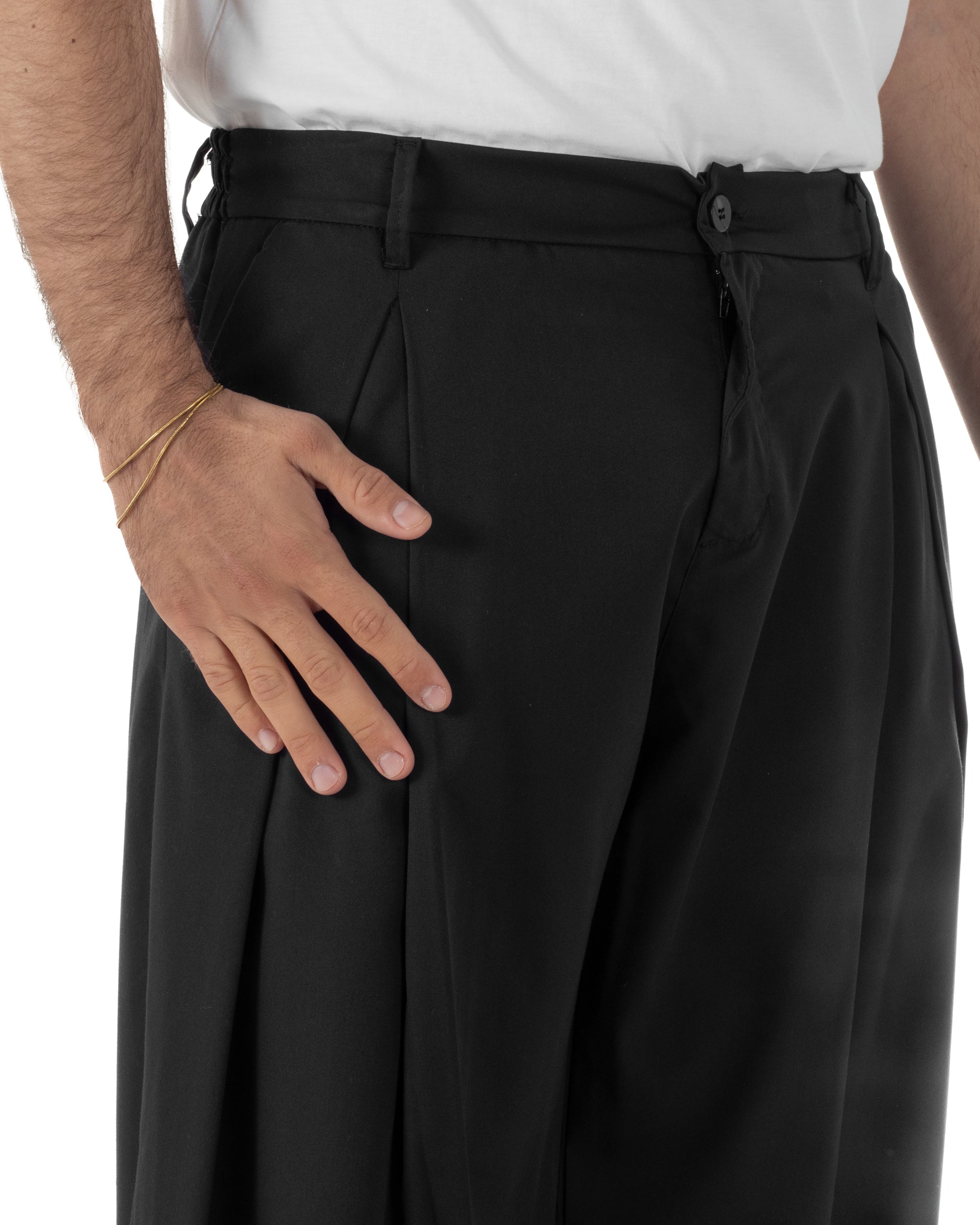 Dettaglio pinces ampie anteriori pantaloni nero baggy wide fit uomo