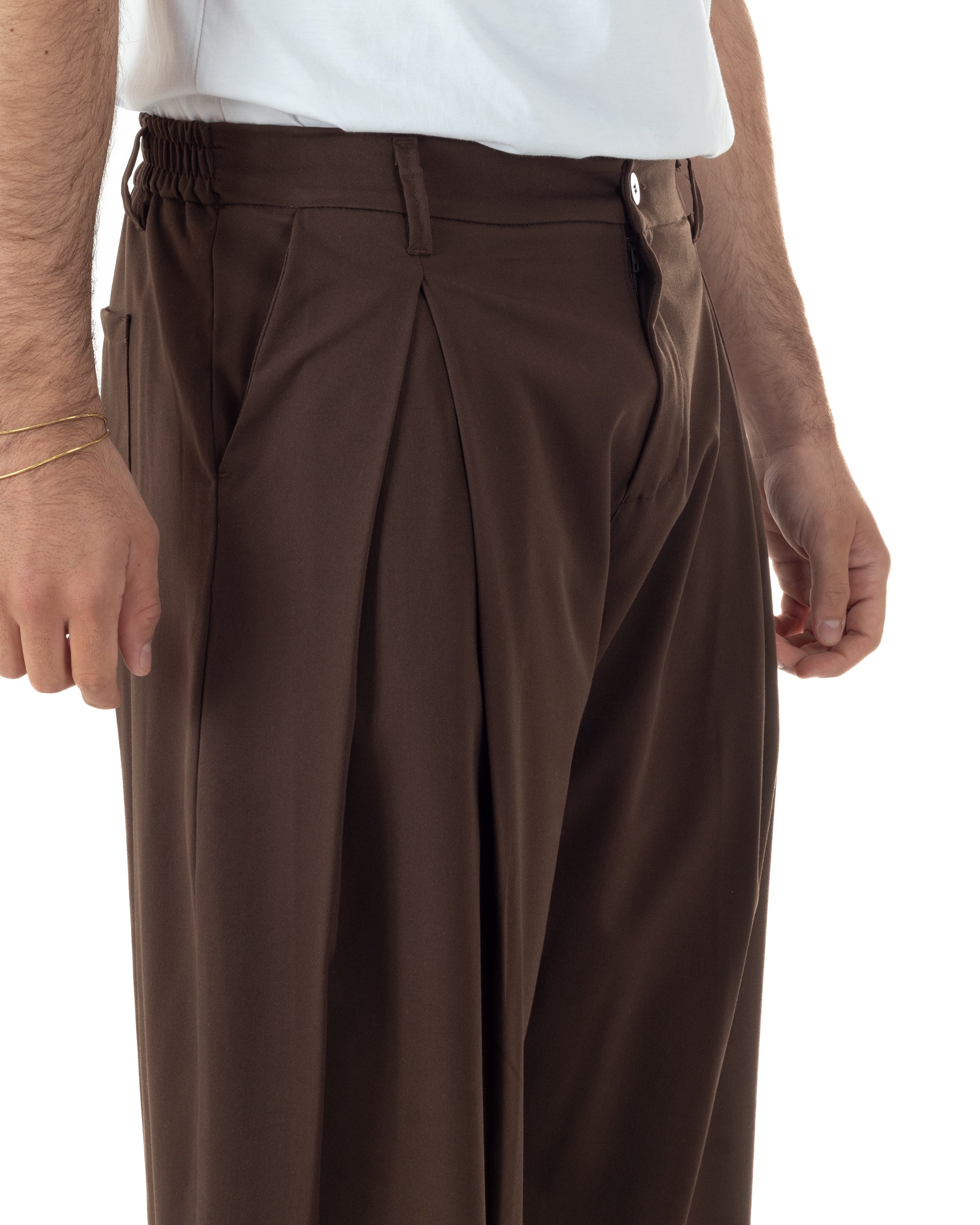 Dettaglio pinces ampie anteriori pantaloni marrone baggy wide fit uomo