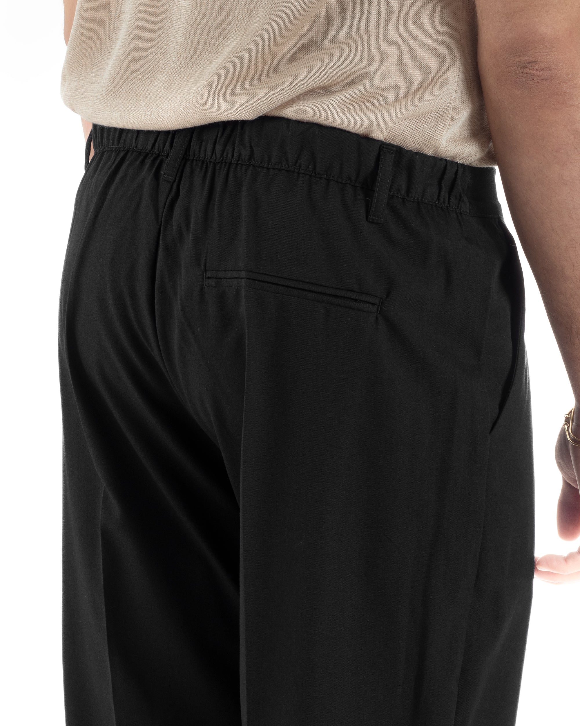 Dettaglio elastico retro e passanti cintura pantaloni nero baggy uomo