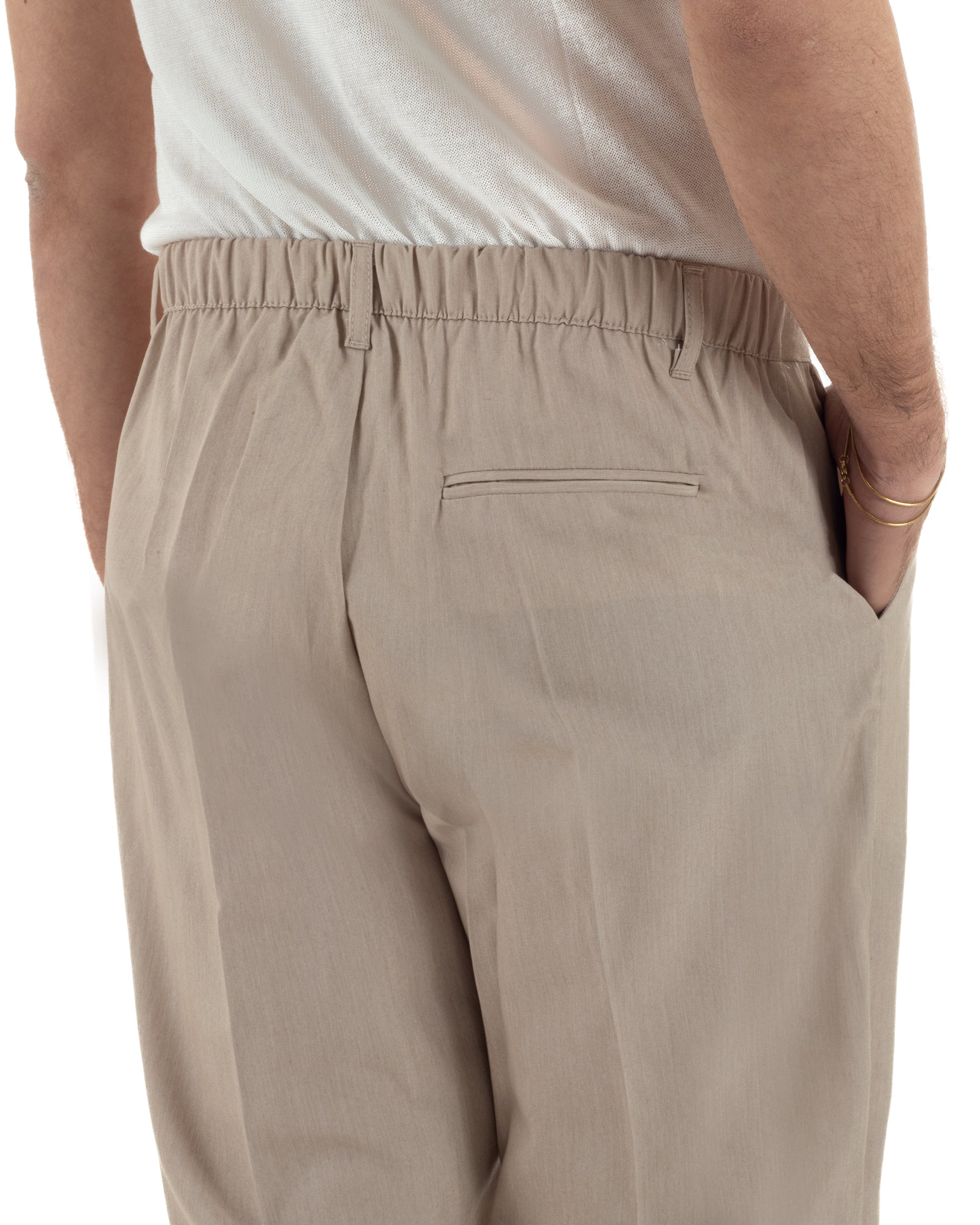 Dettaglio elastico retro e passanti cintura pantaloni beige baggy uomo