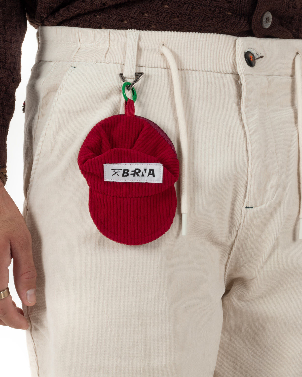 Tasca america e trama a coste fini dei pantaloni color panna, con laccio regolabile sul davanti.