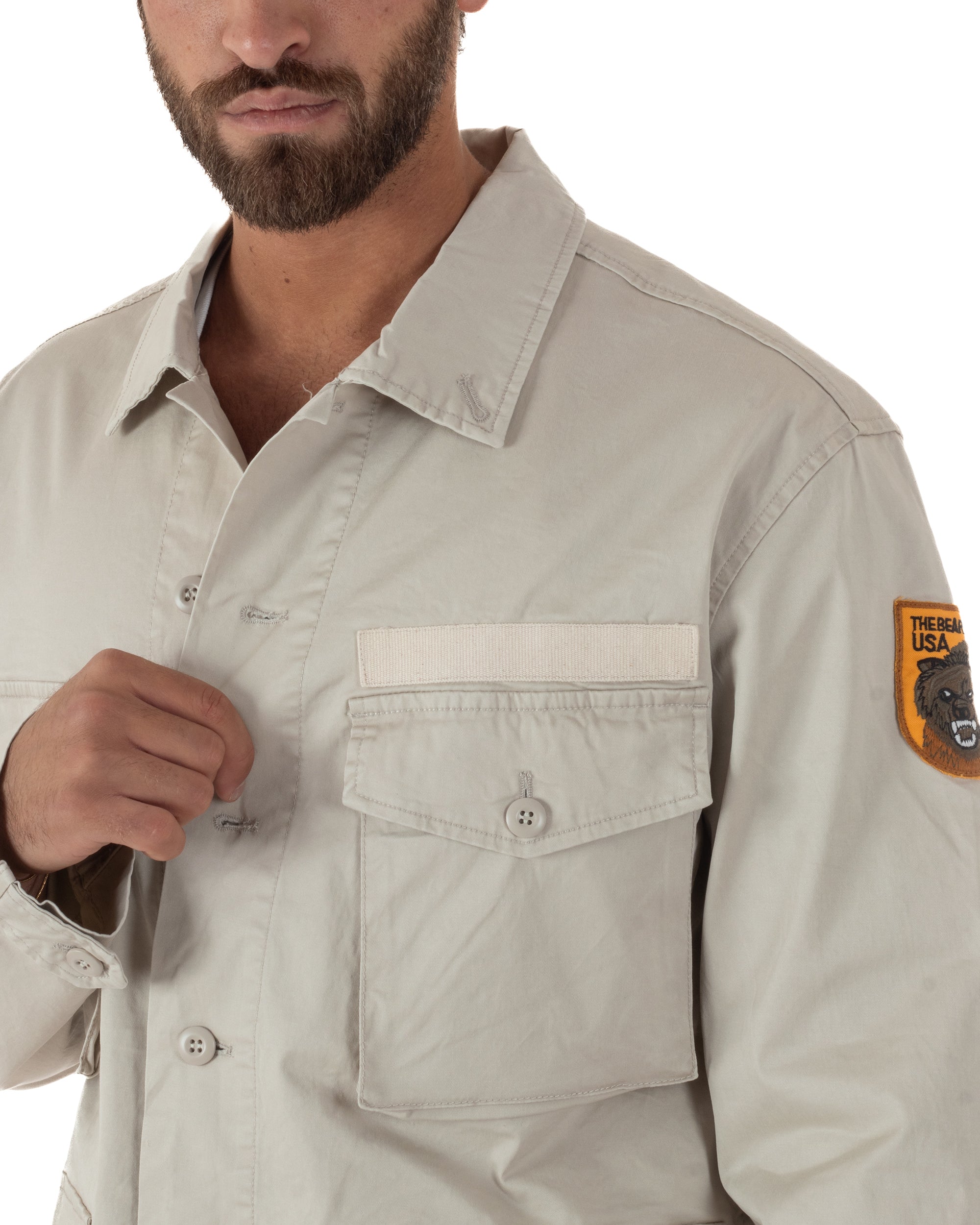 Dettaglio tasche frontali con patta e bottone giacca sahariana beige uomo