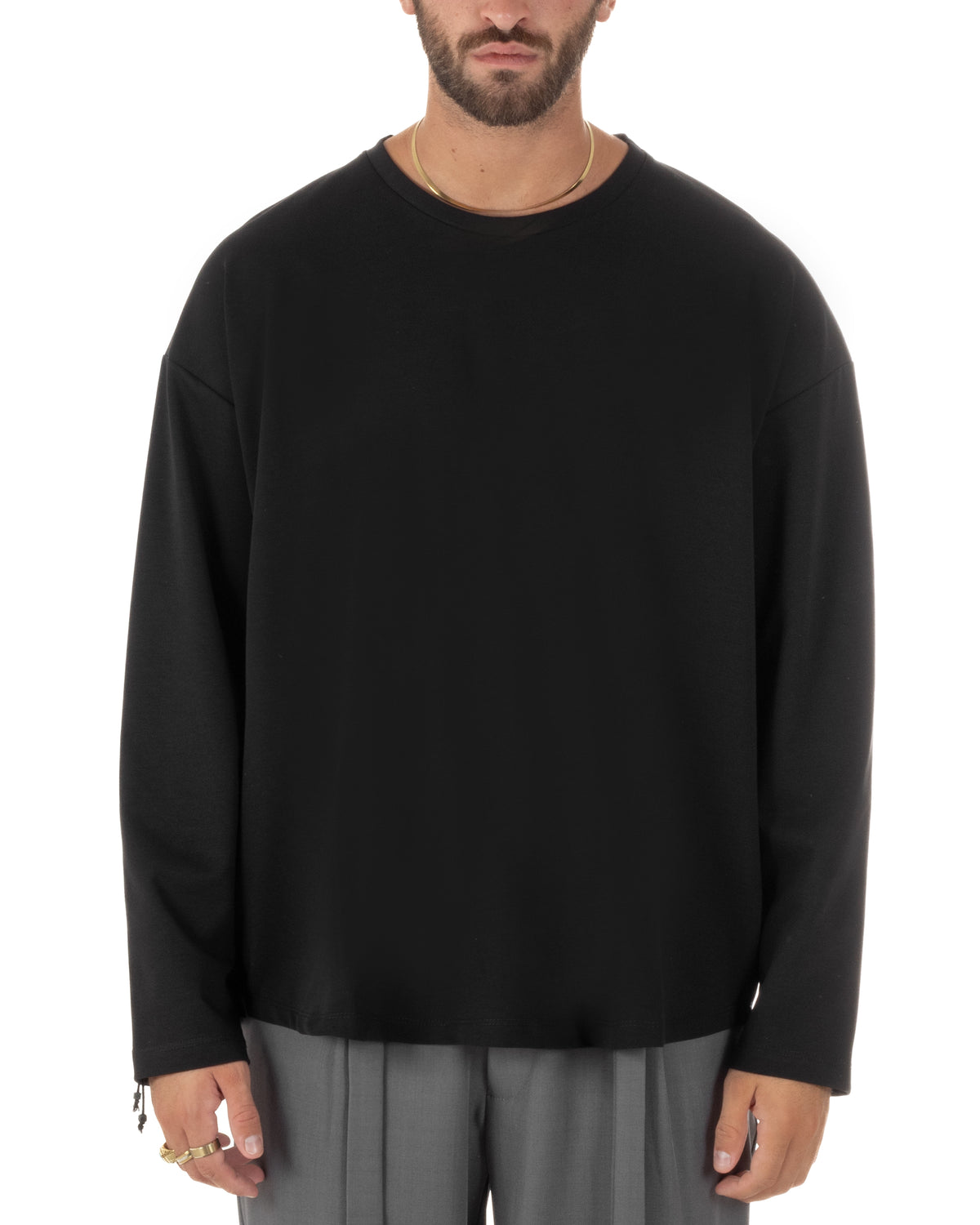 Dettaglio maglia maniche lunghe uomo oversize con  dalla linea regolare, girocollo essenziale e silhouette ampia dal taglio contemporaneo.