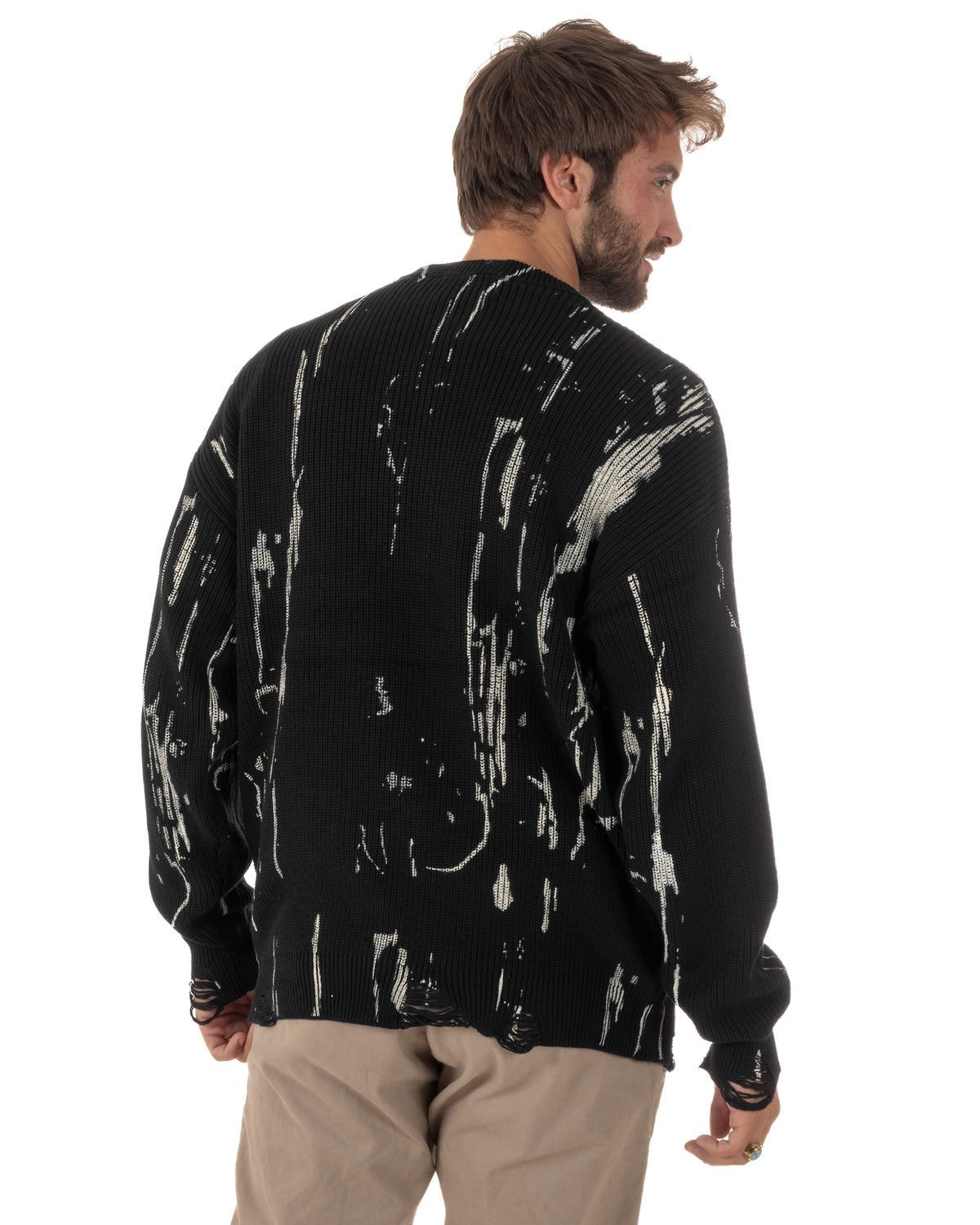 Maglia oversize nera GIOSAL indossata di spalle, con fantasia astratta chiara e fondo strappato.