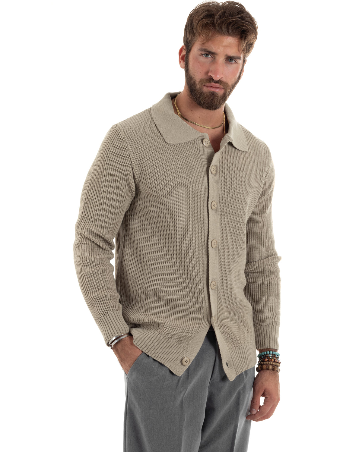 Maglia inglese color fango con abbottonatura centrale, indossata con il collo aperto e una mano in tasca.