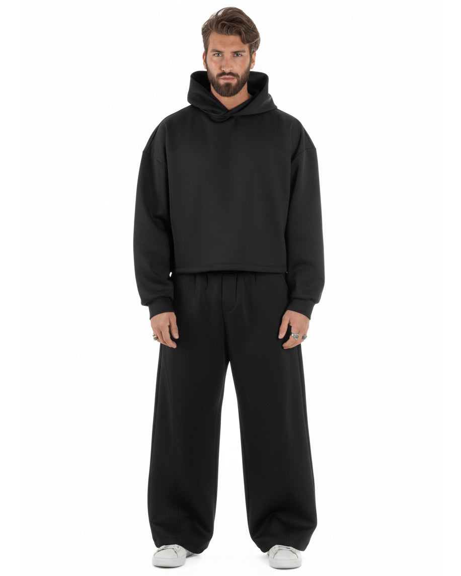 Vista frontale coordinato nero felpa crop con cappuccio pantaloni baggy
