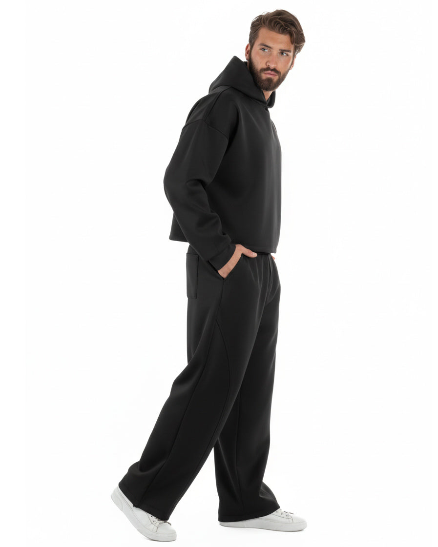 Vista laterale coordinato uomo nero felpa boxy crop pantaloni baggy fit