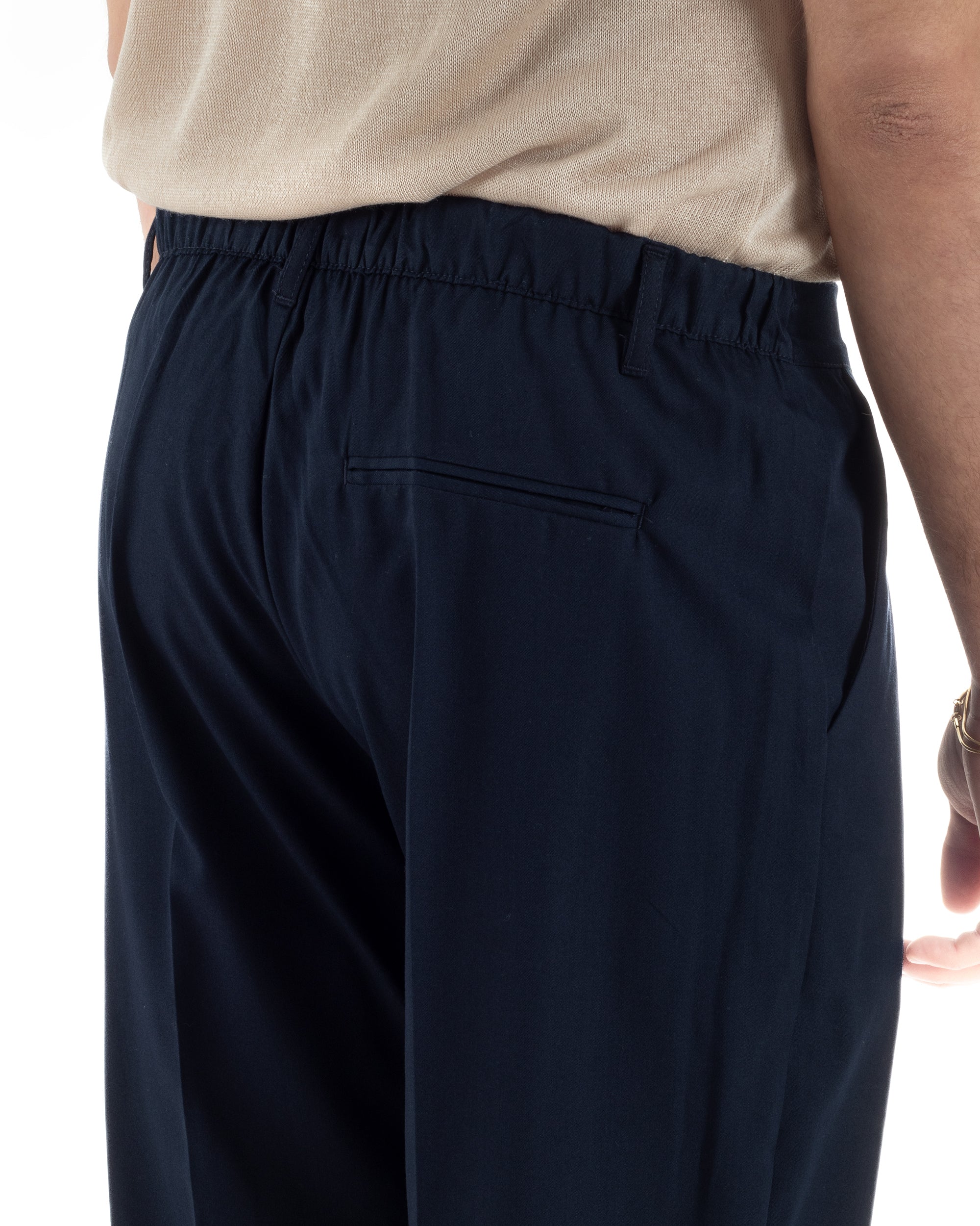 Dettaglio elastico retro e passanti cintura pantaloni blu baggy uomo